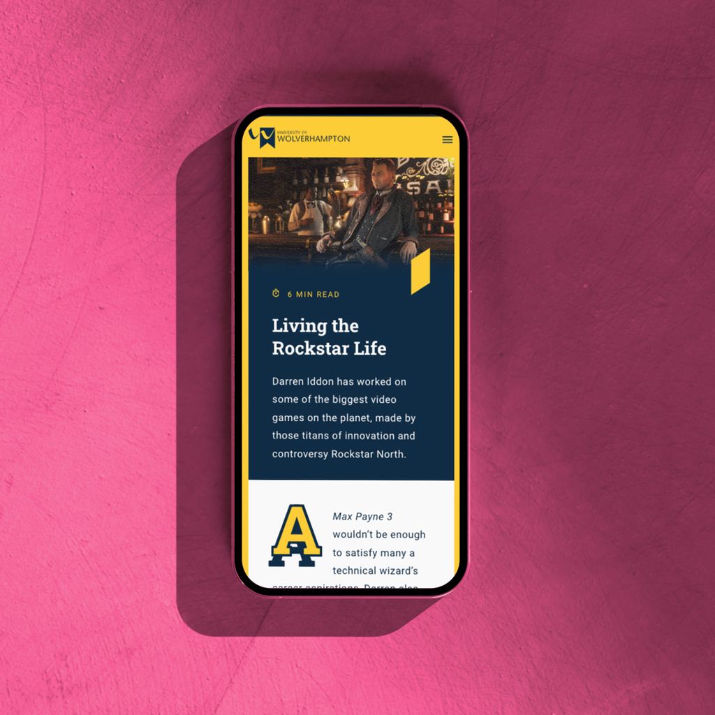 A smartphone atop a bright pink plaster slab. The smartphone screen displays an article about the video game Max Payne 3.