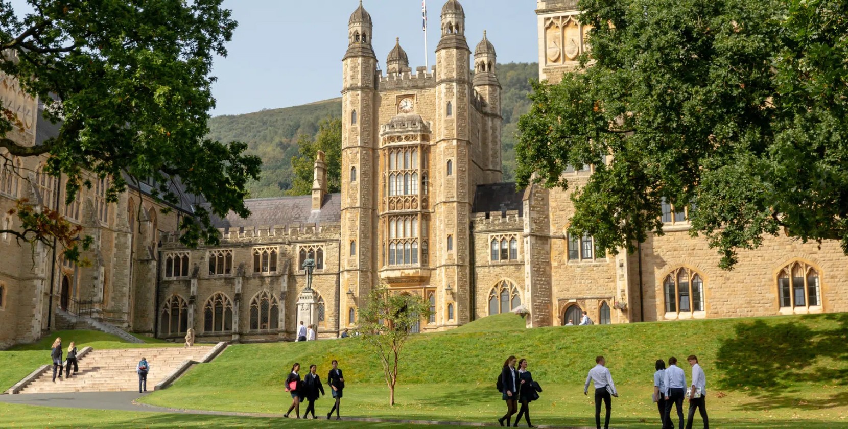 Students walking past the traditional architecture of Malvern College.