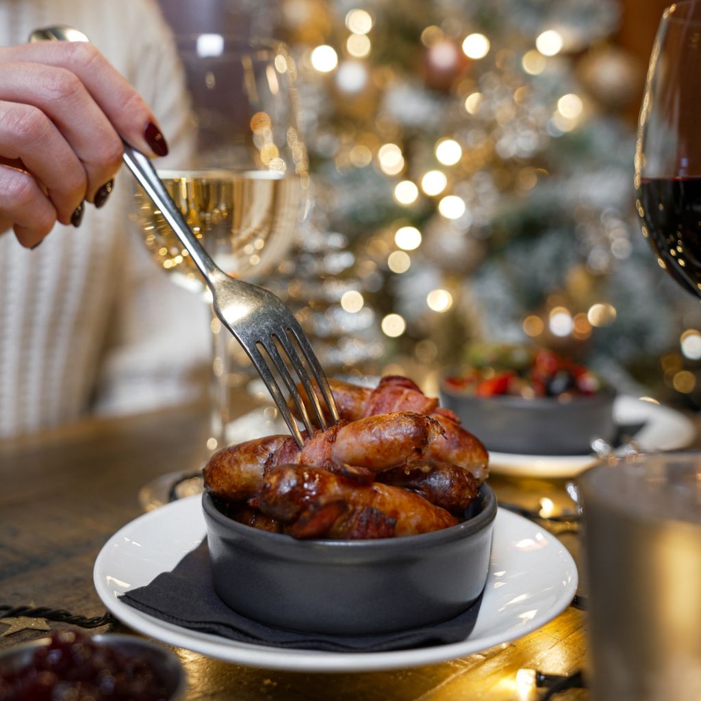 A guest about to enjoy some festive pigs in blankets.