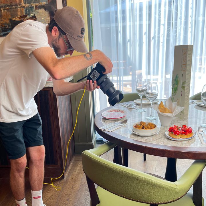 Behind-the-scenes photo of a brand photographer snapping social media content inside a Pesto restaurant.