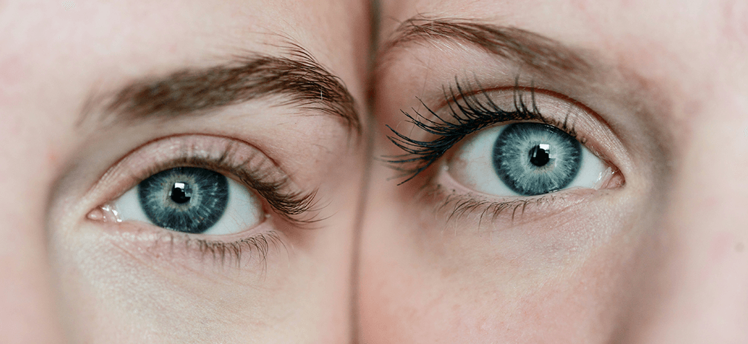 Two people with similarly striking blue eyes, cheek to cheek and staring into the camera. 