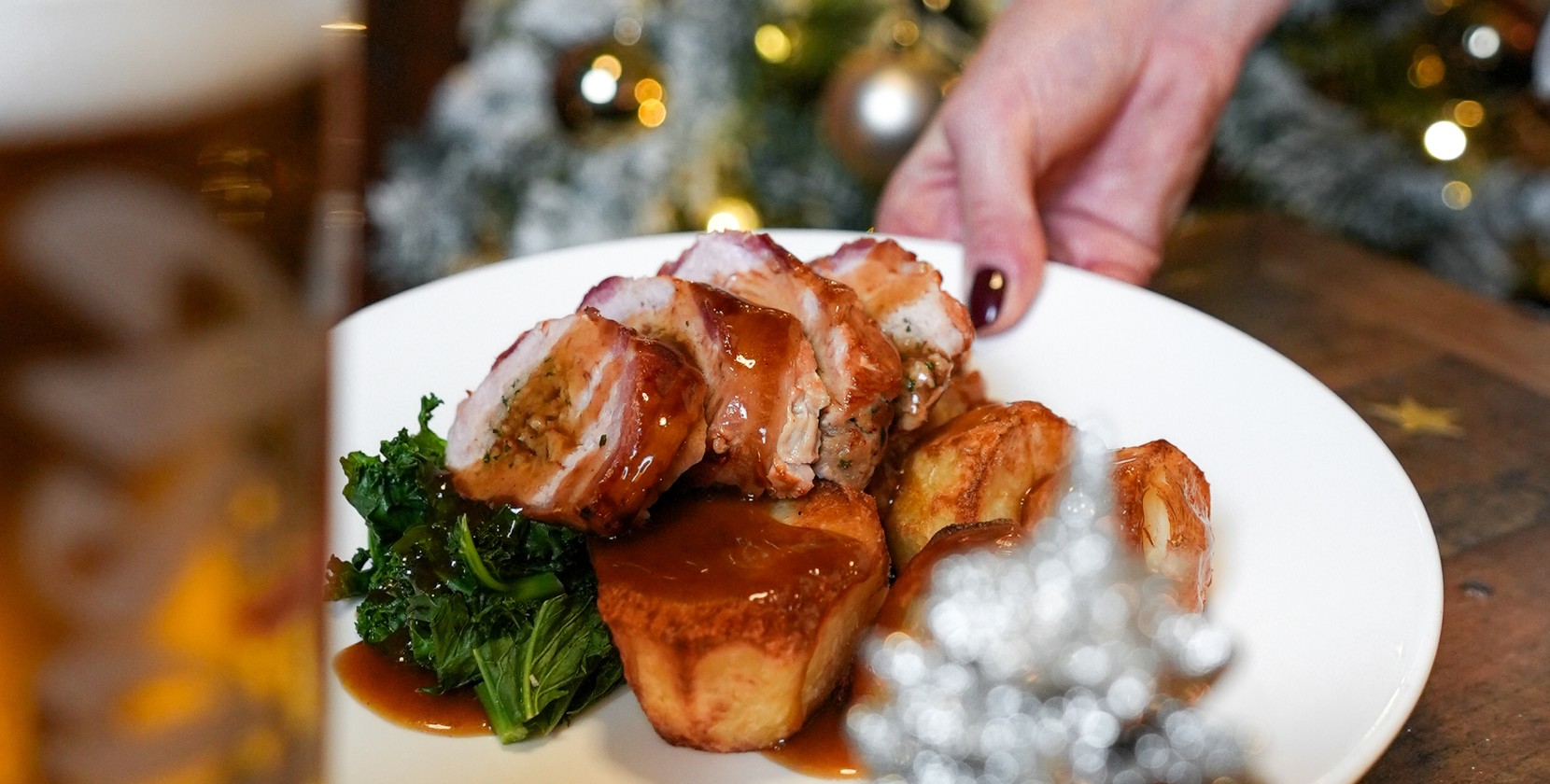 A team member serving a delicious pub roast, smothered in gravy.
